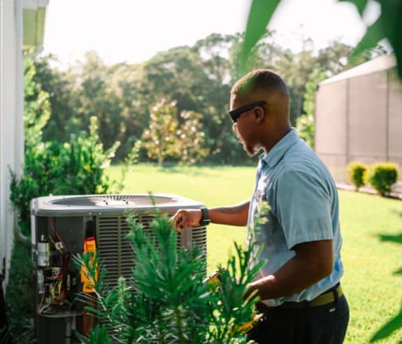 Millian Aire Tech Servicing An AC Unit At A Customer's Home