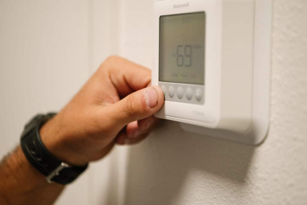 A Millian Aire technician turning on a new thermostat