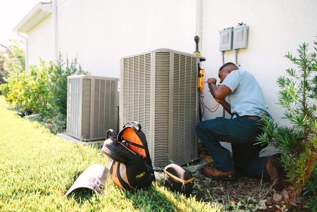 Millian Aire technician working on an AC unit outside