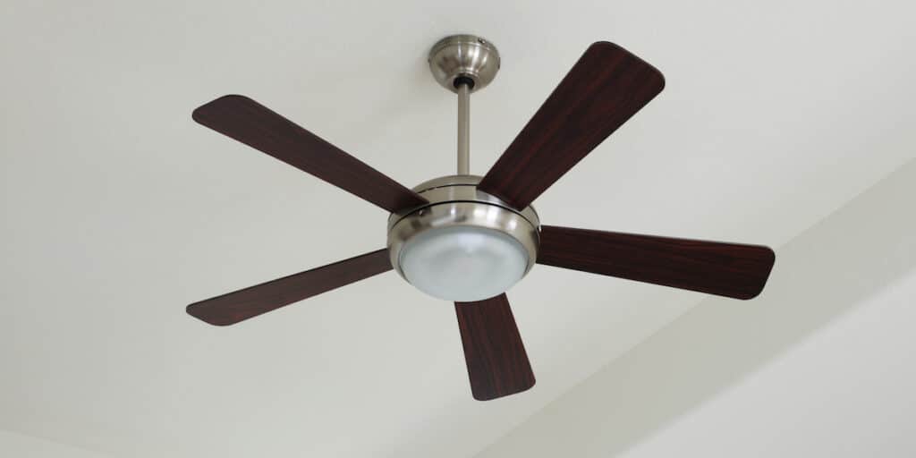 A ceiling fan inside of a bedroom