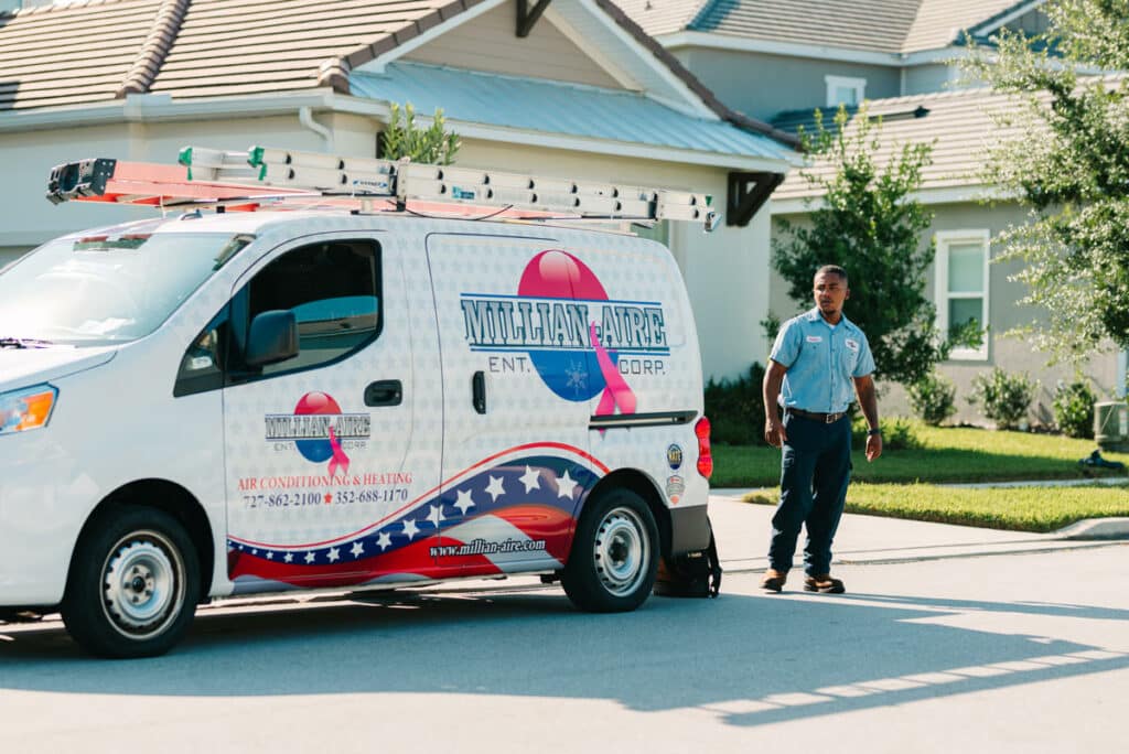 Millian Aire Technician by a branded Millian Aire Service vehicle