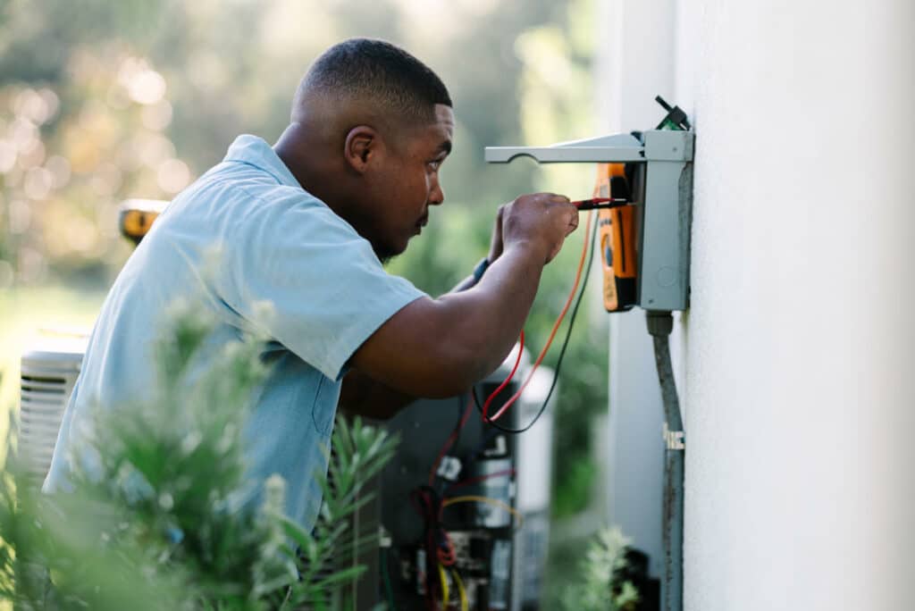 Millian Aire Technician installing surge protectors for air conditioner units