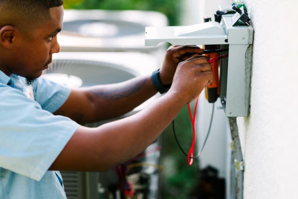 Millian Aire Technician installing a surge protector for air conditioner units